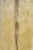 A close-up view of a beige lambskin car seat cover with a zipper. Produktbild-Vorschau