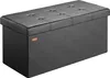 A black storage ottoman with a tufted lid sits on a black surface. Anteprima dell’immagine prodotto