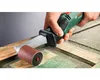 A hand is holding a Bosch sander and using it to sand a wooden surface. Podgląd zdjęcia produktu
