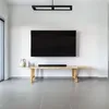 A minimalist living room setup with a TV mounted on the wall above a wooden bench. Produktbild-Vorschau
