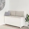 A white wooden storage bench with beige cushions and a gray pillow sits in a room corner next to a large circular wall art and a potted plant. Náhľad obrázku produktu