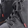 Close-up of black shoelaces with red tips on a black boot. Produktbild-Vorschau