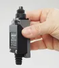 A hand holding a black and gray industrial switch. Produktbild-Vorschau
