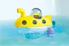 A yellow toy submarine with a figure inside, floating in blue water with a purple octopus toy nearby. Anteprima dell’immagine prodotto