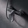 A close-up shot of a dark gray shower faucet mounted on a textured dark gray wall. Produktbild-Vorschau