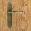A close-up of a door handle with a keyhole on a wooden door. Produktbild-Vorschau