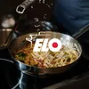 A person is grating cheese over a frying pan filled with pasta and broccoli. Produktbild-Vorschau