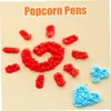Rote und blaue strukturierte Formen, darunter eine große rote Spirale und zwei blaue Herzen, auf hellbeigem Hintergrund mit dem Text "Popcorn Pens" Voir les images du produit