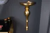 A decorative gold wall console mounted on a dark gray wall. Produktbild-Vorschau