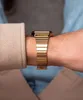 Close-up of a person's wrist wearing a gold watch. Voir les images du produit