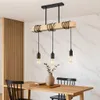 A dining room setting with a wooden table and chairs, illuminated by a pendant light. Produktbild-Vorschau