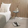 A body composition scale is placed on the floor next to a bed in a bedroom setting. Produktbild-Vorschau