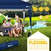 A family is enjoying a picnic under a blue canopy tent next to a lake. Anteprima dell’immagine prodotto