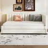 A beige daybed with several decorative pillows on a light-colored rug with a black abstract pattern. Náhľad obrázku produktu