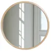 A round mirror with a natural wood frame is shown against a light-colored wall with window light reflections. Anteprima dell’immagine prodotto