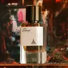 A perfume bottle is displayed on a wooden surface with a pile of peppercorns and chili peppers in the foreground. The background is blurred and shows colorful abstract shapes. Produktbild-Vorschau