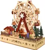 A wooden Ferris wheel decoration with small figures and a house, set on a decorated base. Náhled obrázku produktu