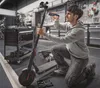 A man is kneeling and working on an electric scooter in a workshop. Voir les images du produit