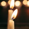 Close-up of two lit candles with bokeh lights in the background. Podgląd zdjęcia produktu