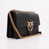 A black leather handbag with a gold chain and a gold bird emblem. Voir les images du produit