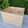A wooden crate is shown outdoors, with greenery in the background and a wooden surface in the foreground. Náhled obrázku produktu