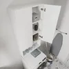 A white cabinet with open doors, revealing shelves with various items, placed next to a washing machine and an ironing board. Produktbild-Vorschau