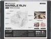 The back of a product box for a ROKR 3D-Holz-Puzzle Murmelbahn / Kugelbahn 'Marble Spaceport'. The box features a detailed diagram of the marble run, feature callouts, other model examples, and product information. Podgląd zdjęcia produktu