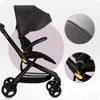 A close-up view of a black stroller with gold accents, featuring detailed shots of the fabric texture and a hinge mechanism. Anteprima dell’immagine prodotto