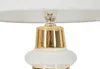 Close-up of the top part of a table lamp with a white lampshade and a gold and white base. Náhľad obrázku produktu