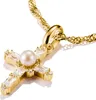 A close-up shot of a gold cross pendant with a pearl and clear stones, attached to a gold chain. Voir les images du produit