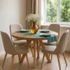 A round dining table with four chairs set in a dining room with a window in the background. Produktbild-Vorschau