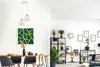 A modern dining room and living room area with a pendant light over a dining table and a bookshelf with plants and decor. Produktbild-Vorschau