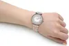 A woman's wrist wearing a silver and rose gold watch. Voir les images du produit
