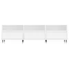 A white TV cabinet with three sections, each with an open shelf above a drawer, supported by angled legs. Náhled obrázku produktu