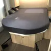 A bed with a fitted sheet in a room that appears to be a campervan or RV. Produktbild-Vorschau