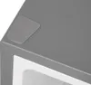 A close-up, angled view of the top corner of a refrigerator with a protective grey sticker on its surface. The interior of the refrigerator is visible below. Produktbild-Vorschau