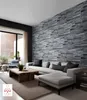 A modern living room with a sectional sofa, coffee table, and a stone-patterned accent wall. Náhľad obrázku produktu