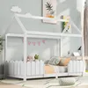 A white house-shaped bed frame with a picket fence-like railing, decorated with pink pennant flags and stuffed animals. Náhled obrázku produktu