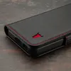 A close-up shot of a black leather phone case with red stitching and a red bull logo. Anteprima dell’immagine prodotto