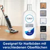 A Tineco cleaning solution bottle is shown next to a Tineco wet dry vacuum cleaner being used on a wooden floor. Several different floor types are illustrated on the right side of the image. Produktbild-Vorschau