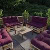 An outdoor seating area on a balcony or patio, furnished with pallet furniture and cushions. Voir les images du produit