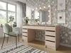 A bedroom vanity with a lighted mirror, a chair, and decorative elements. Voir les images du produit
