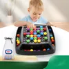 A young child is playing with a colorful ball game on a table. Produktbild-Vorschau