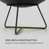 Close-up of the base of a black fire pit, showing its three-legged construction and a graphic overlay indicating stability. Produktbild-Vorschau
