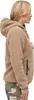A woman wearing a tan teddy fleece jacket and camouflage pants, shown from the side. Produktbild-Vorschau