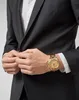 A man in a suit wearing a gold watch. Podgląd zdjęcia produktu