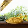 A wooden bowl filled with birdseed sits on a wooden surface, with a blurred background of greenery and flowers. Produktbild-Vorschau