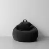 A dark gray bean bag chair sits against a white wall on a light gray floor. Voir les images du produit