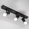 A black ceiling light fixture with three adjustable spotlights is mounted on a white ceiling. Náhľad obrázku produktu