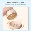 A hand holding a mini vacuum cleaner with its debris bin detached and filled with small particles. Náhled obrázku produktu